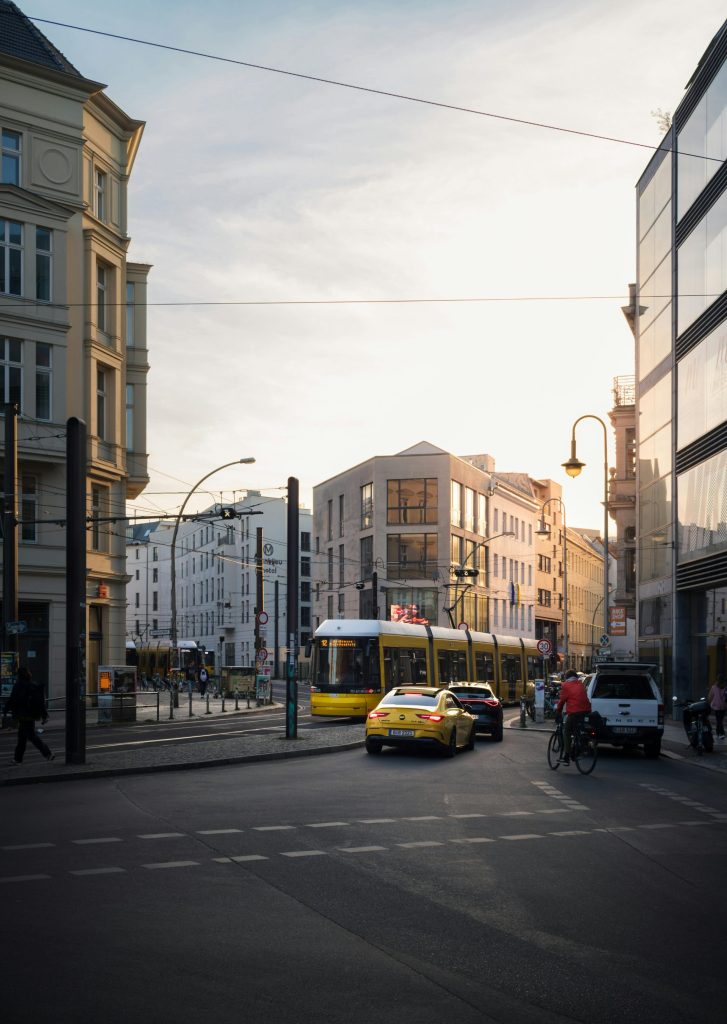 Ein gelber Bus fährt neben einem gelben Taxi eine Straße entlang und zeigt den städtischen Nahverkehr in Bewegung.